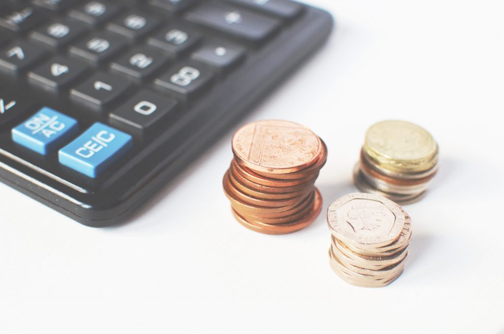 stack of coins next to calculator